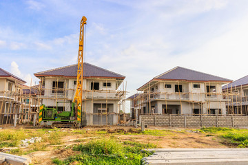 New house building at residential estate construction site with clouds and blue sky