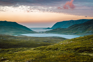 Nord summer Norwegian landscape behind the polar circle with green hills, sea bay, lake and camp...