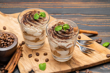 Classic tiramisu dessert in a glass on wooden background