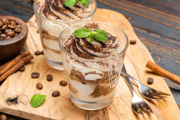 Classic tiramisu dessert in a glass on wooden background