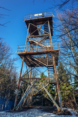Old rusty observation tower on the peak of Mount Kalenica in Owl Mountains Landscape Park, protected area in Lower Silesia Province of Poland - obrazy, fototapety, plakaty