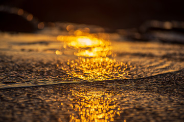 sunset light reflection in the beach wet sand and water