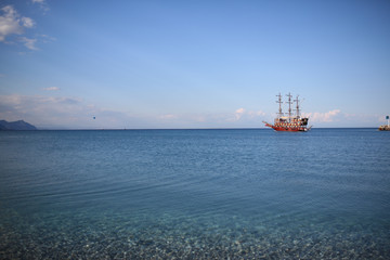 Ship at sea, Kemer in Turkey. Pebble beach