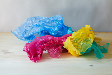 Fototapeta premium used crumpled colorful plastic bags and wraps on wooden table