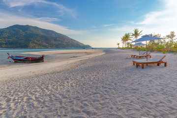 Beach chairs, umbrella and palms on the beautiful beach for holidays and relaxation at Koh Lipe island, Thailand