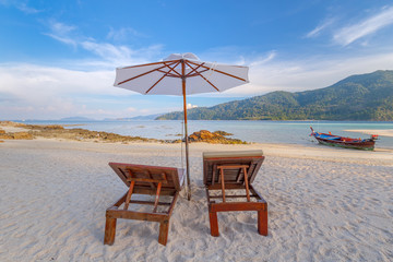 Beach chairs, umbrella and palms on the beautiful beach for holidays and relaxation at Koh Lipe island, Thailand