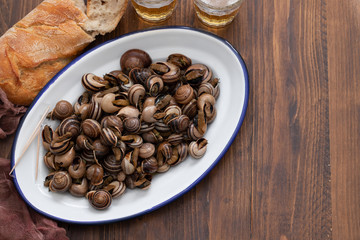 boiled snails with herbs in white dish