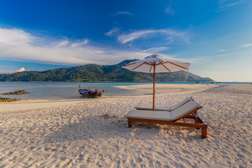 Beach chairs, umbrella and palms on the beautiful beach for holidays and relaxation at Koh Lipe island, Thailand