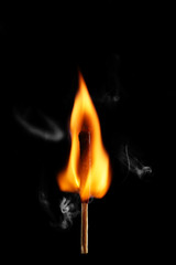 Burning match on dark background
