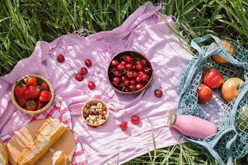 Zero waste summer picnic on the with cherries in the wooden coconut bowls, fresh bread and glass...