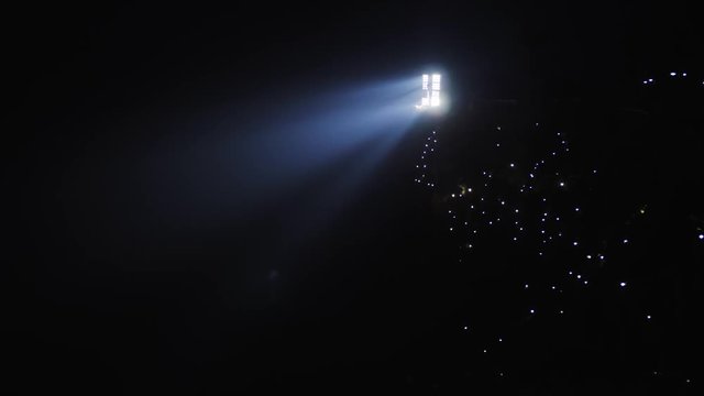 Stadium light against dark night sky background with magic lights around