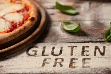A gluten free pizza on  a rustic wood background