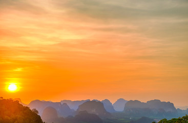 Landscape with beautiful dramatic sunset and silhouette of blue mountains at horizon in Thailand. HDR image