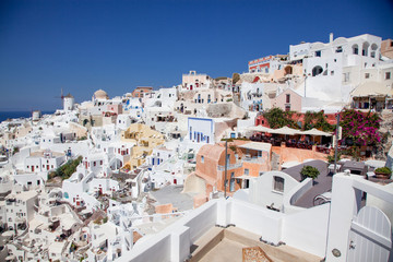 beautiful Oia town on Santorini island, Greece. Traditional white architecture and greek orthodox churches with blue domes over the Caldera, Aegean sea. Scenic travel background