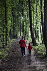 Obraz premium Mother with her little daughter walking through the forest