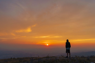 Silhouette of man on top of mountain at sunset
