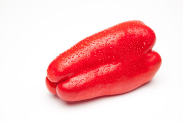 Pimiento rojo sobre fondo rojo con gotas de agua que denotan frescor.