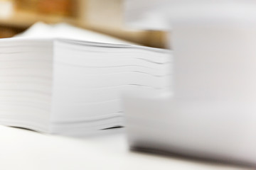 Stacked paper sheets on office desk.