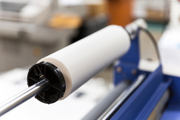 Paper roller equipment in industrial print shop.