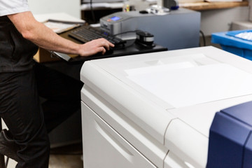 Printer operating technical printing equipment in factory space.