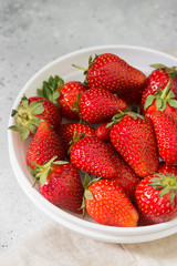 Strawberry in white plate on light background