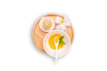 Spa salt in bottles with frangipani flowers. Spa salt, yellow-orange in the cup with a spoon setting isolated on white background. Aromatic sea salts, handmade natural spa products concept.