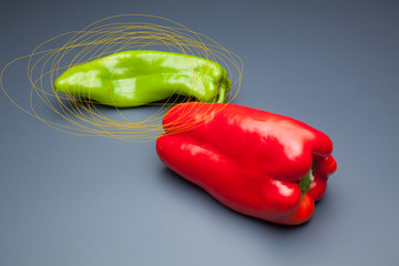 Pimiento verde y pimiento rojo, sobre fondo gris