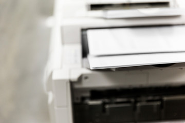 Office printer printing out documents quickly into ordered stack.