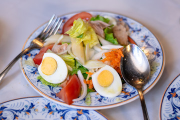 Mixed salad in a decorated plate with fork and spoon. Spanish gastronomy.