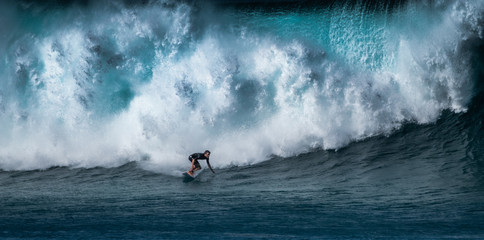 Surfer rides huge wave at the famous Banzai Pipeline surf spot located on the North Shore of Oahu...