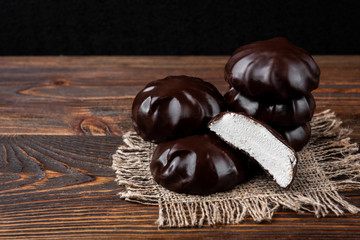 Chocolate marshmallow on dark wooden background.