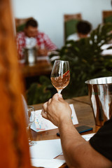 Glass of rose and white wine seen in close hand.