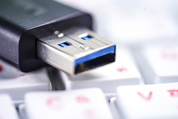 Fototapeta premium USB thumb external drive on white keyboard : technology concept. 