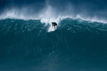 Surfer rides giant wave at the famous Banzai Pipeline surf spot located on the North Shore of Oahu...