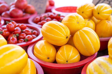 Delicious korean stripe yellow melon fruit food in red plastic basket at tradition market afternoon, Seoul, South Korea, harvest concept, close up.
