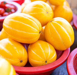 Delicious korean stripe yellow melon fruit food in red plastic basket at tradition market afternoon, Seoul, South Korea, harvest concept, close up.