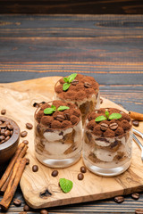 Classic tiramisu dessert in a glass on wooden background