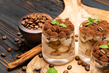 Classic tiramisu dessert in a glass on wooden background