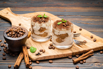 Classic tiramisu dessert in a glass on wooden background