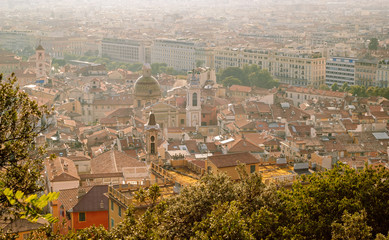 Fototapeta premium During sunset a beautiful view of the old town of Nice from the park Mont Baron. Above view of roofs of old buildings with Mediterranean architecture, narrow streets, churches and cathedrals.