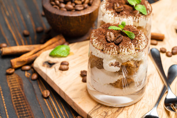 Classic tiramisu dessert in a glass on wooden background