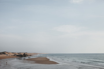 Beautiful ocean seaside. Atlantic coast with a long waves, sand and low horizon
