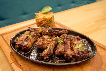 Tasty ribs with garnish on pub or bistro table
