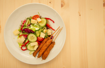 Up view of tasty salad with chicken cheese and raw vegetables