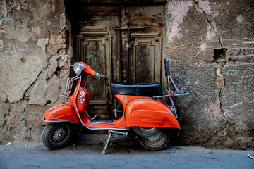 Fototapeta na wymiar Rusty old motorcycle in front of a locked door in the streets of Cairo