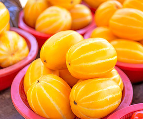 Delicious korean stripe yellow melon fruit food in red plastic basket at tradition market afternoon, Seoul, South Korea, harvest concept, close up.