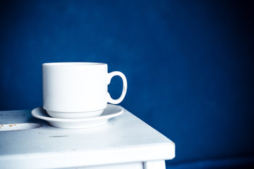 mug on wooden table over grunge background