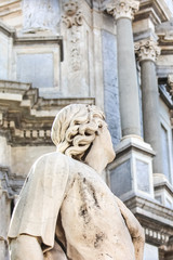 Closeup photography of Antique statue on Baroque Catania Cathedal, Sicily, Italy. The Duomo cathedral is blurred in the background. Marble sculpture