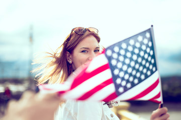 Young patriot modern woman holding USA flag depth of field