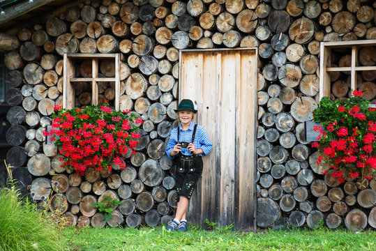 Smiling bavarian boy with flowers on the farm in Germany .Happy little boy wearing a traditional Bavarian clothes